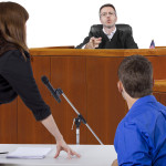 defendant with lawyer speaking to a judge in the courtroom